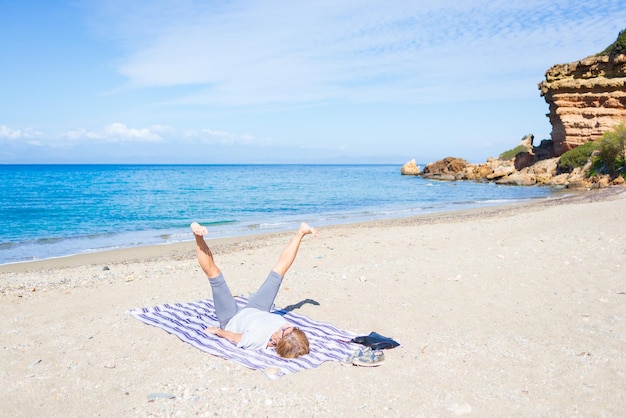 写真 ギリシャの美しい空っぽのビーチでヨガの練習をしている女性 劇的な海岸線 景色の美しい湾 イオニア諸島の岩の崖