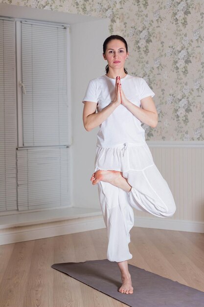 Donna che esegue yoga posa sul pavimento in studio domestico yoga e sport concept