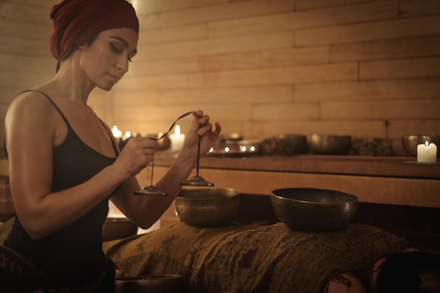 Foto una donna esegue un rituale tibetano con campane sonore il concetto di terapia