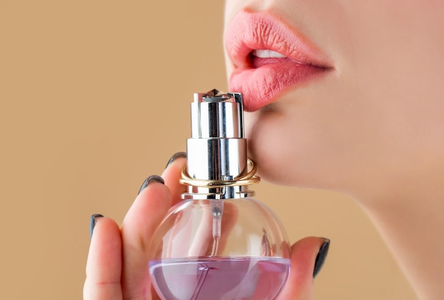 Woman perfumes bottle. Sexy lips. Pink lip. Close up of sexy plump soft lips with dark red lipstick