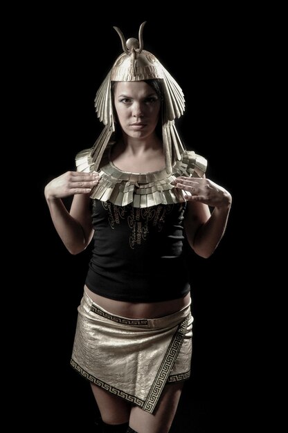 Woman in a Pharaoh's clothes on a dark background.