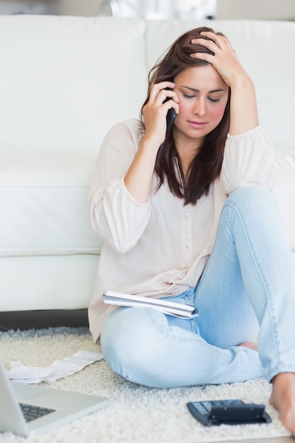 Женщина по телефону получает стресс над счетами
