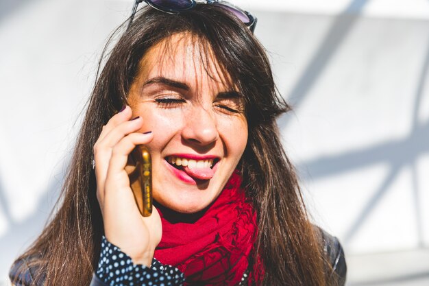 Woman on the phone showing tongue out to the camera