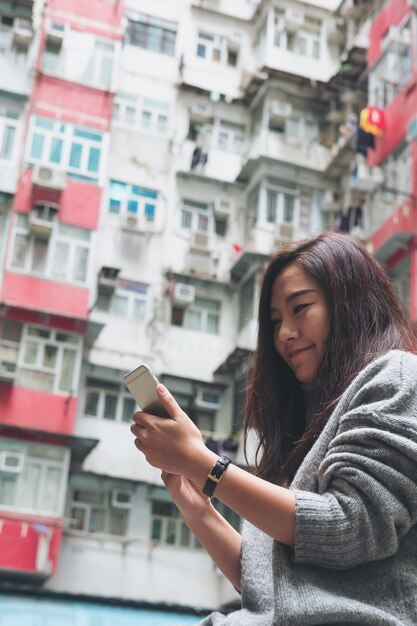 Woman and phone with building background