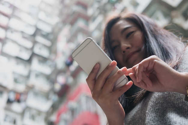 Woman and phone with building background