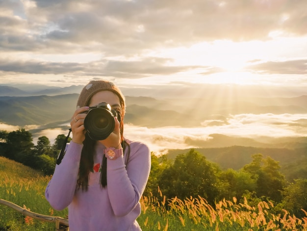 Foto fotografo della donna che tiene una macchina fotografica in natura