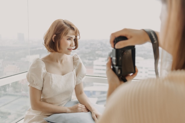 Woman photographer is taking a photo of her woman fashion model