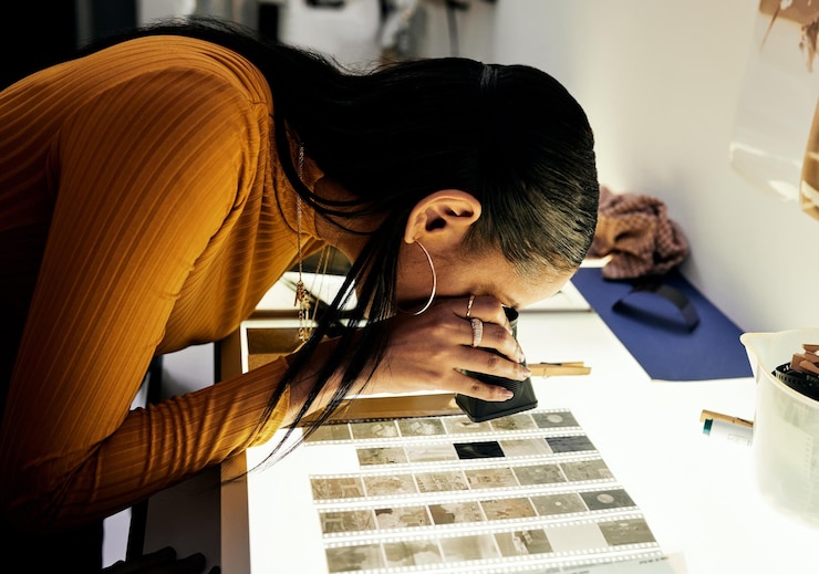 Photo woman photographer and magnifying glass for film negatives zoom and analysis for photo journalist job photography expert analyse picture and focus in studio for choice decision and creativity