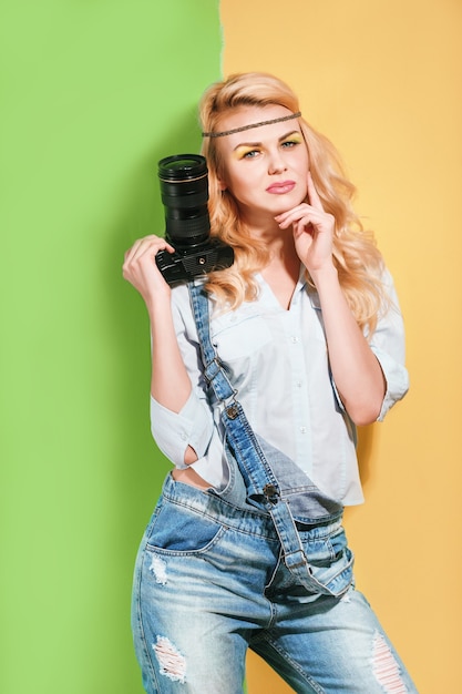 Woman photographer making shots on a bright color background on a sunny day