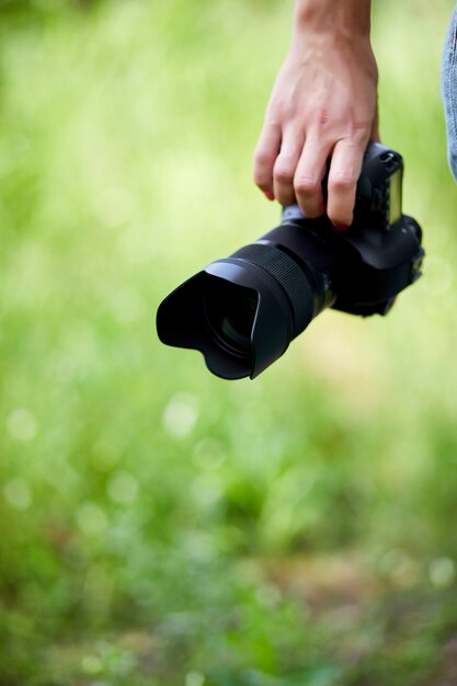 Fotografo di donna con una macchina fotografica in mano all'aperto