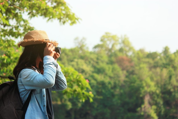 空の向こうの木の向こうで写真を撮っている女性