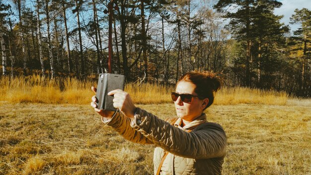 写真 樹木の向こうで写真を撮っている女性