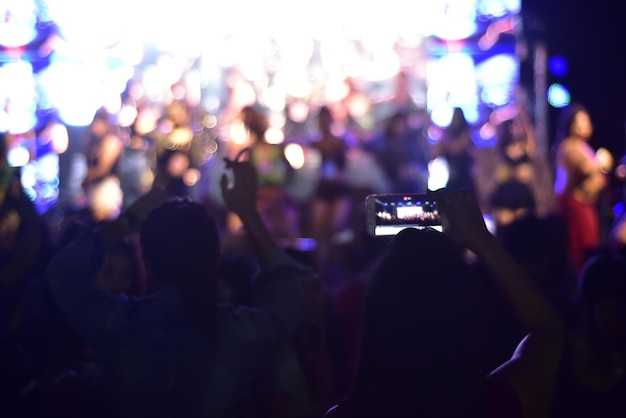 写真 音楽コンサートで写真を撮っている女性