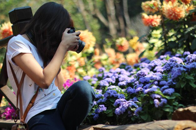Photo woman photographing flowering plants