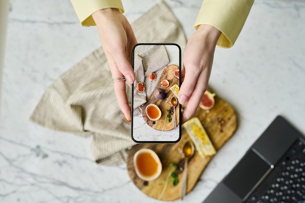 Woman photographing food on her mobile phone