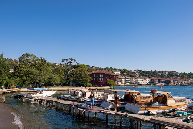 Foto donna che fotografa un'amica sul molo del porto