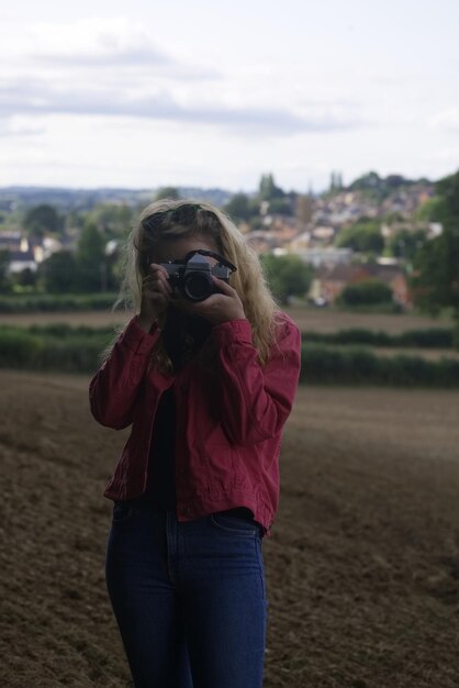 Woman photographing from camera on field