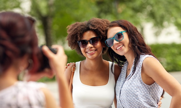 woman photographing her friends in summer park