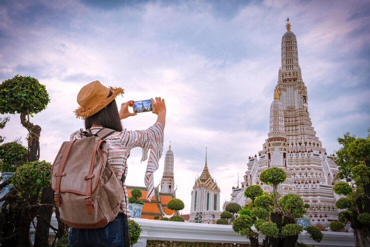 Photo woman photographing temple with smart phone