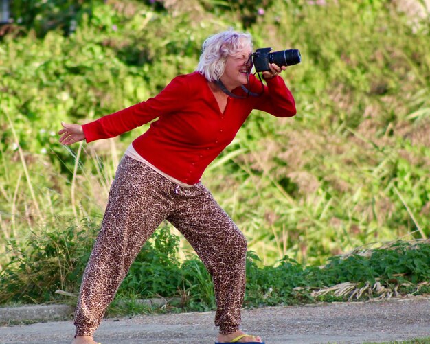 Photo woman photographing through camera against plants