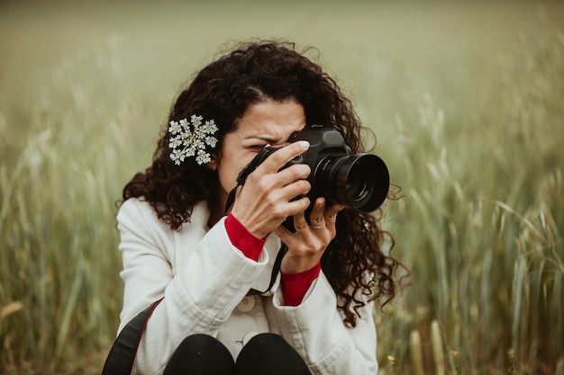 Photo woman photographing through camera on field