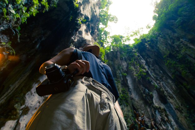 Woman photographing through camera on mountain