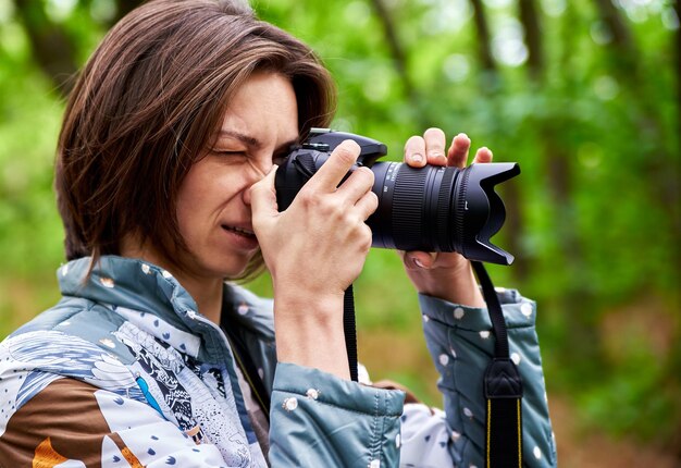 Фото Женщина фотографирует с помощью камеры на открытом воздухе