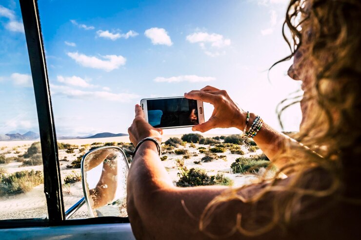Фотография женщина фотографирует с помощью смартфона на небе
