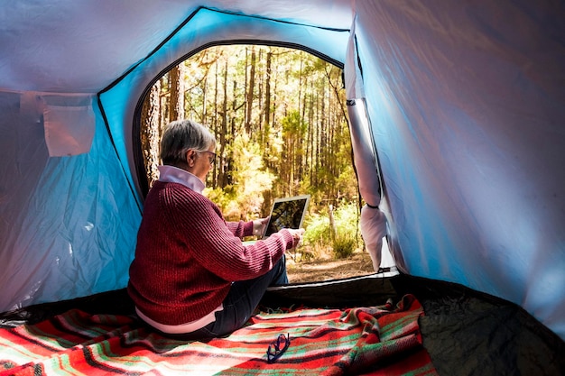 写真 女性がテントに座って木を写真に撮っている
