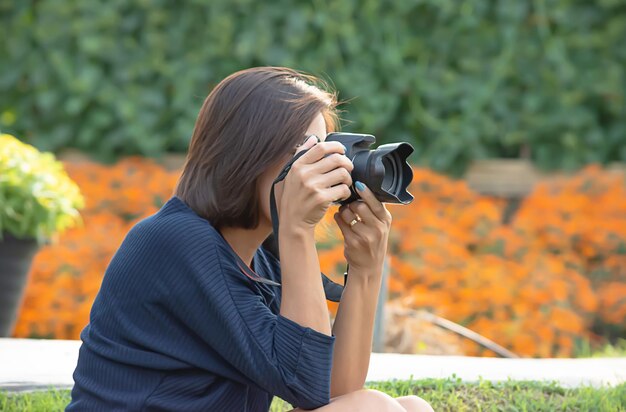 庭でカメラで写真を撮っている女性