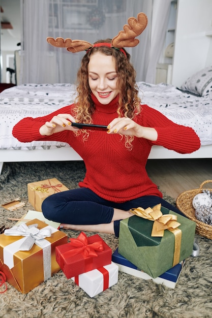 包まれたプレゼントを撮影する女性