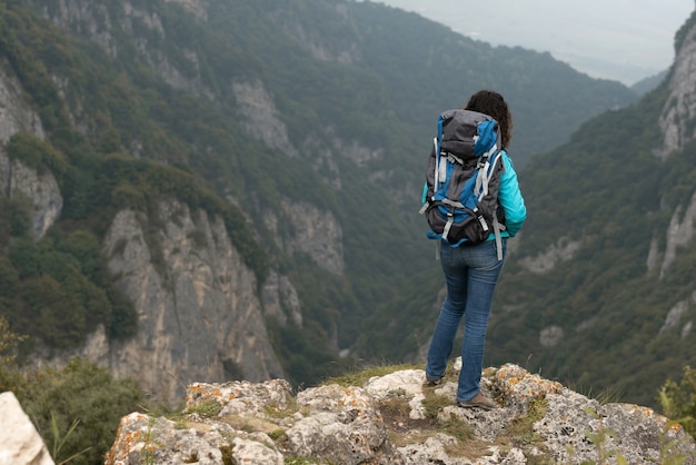 女性が山の中の風景を撮影します。