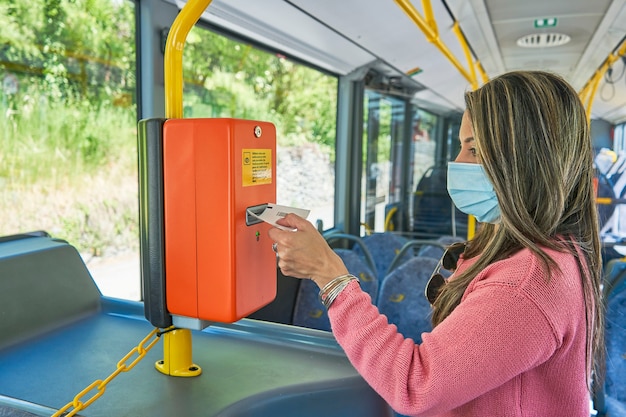 Woman picking up ticket from the bus paying machine close up