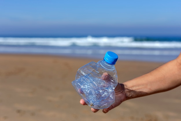 Woman picking up trash and plastics cleaning the beach