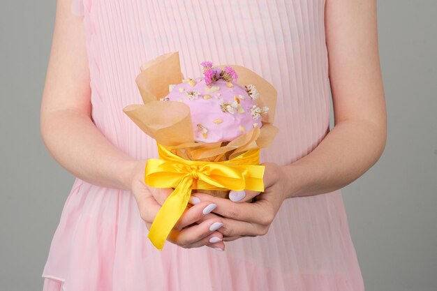 A woman in a pink dress holds a bouquet of flowers