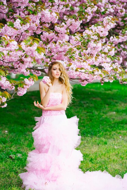 花の近くのピンクのドレスの女性