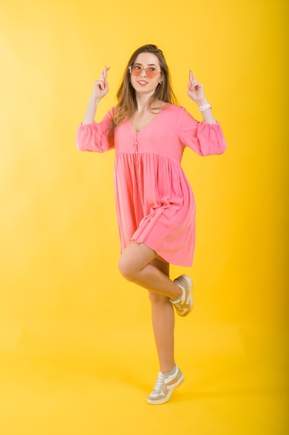 Woman in pink dress on yellow background