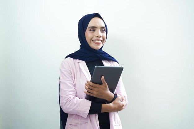 A woman in a pink jacket holds a tablet in her hand.