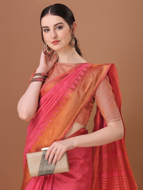 A woman in a pink saree with a red and orange saree