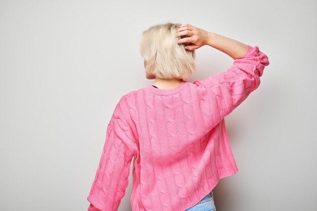 Photo woman in pink shirt scratching head puzzled expression on grey background