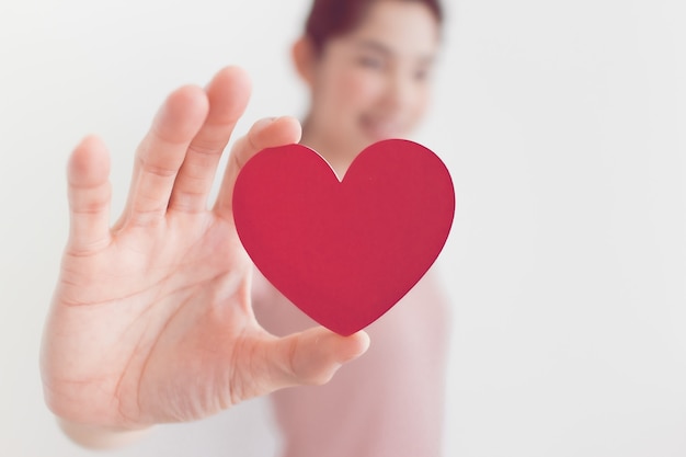 Woman in pink shows heart shape in the concept of love and valentine.