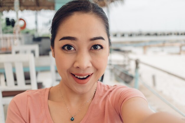 Woman in pink t-shirt selfie herself with happy face.