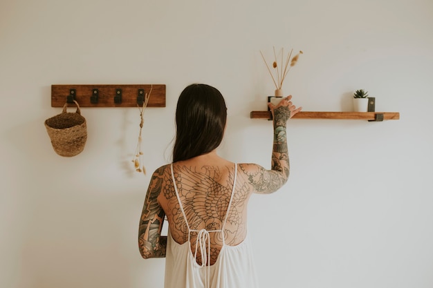 Woman placing aroma diffuser on wall shelf