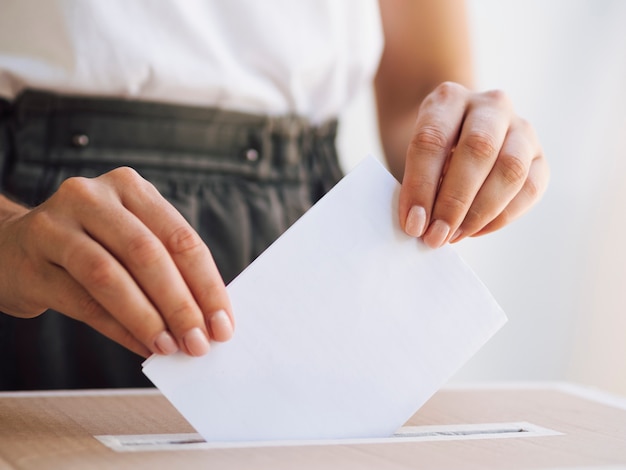 Photo woman placing ballot in box