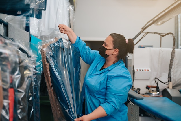 woman placing the suit jacket that she has ironed in her business