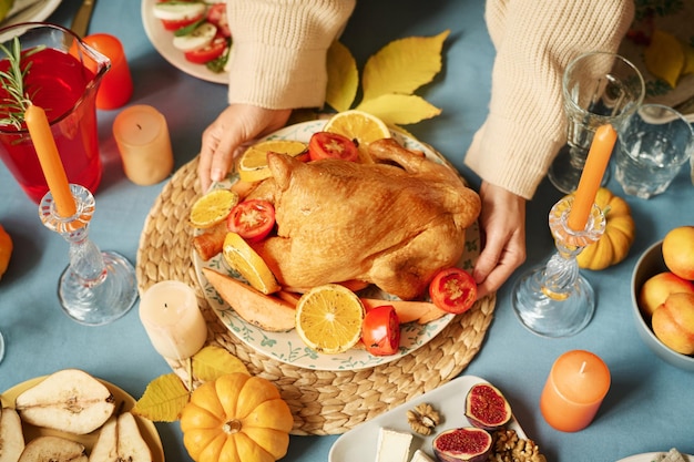 Фото Женщина кладет индейку на стол на день благодарения