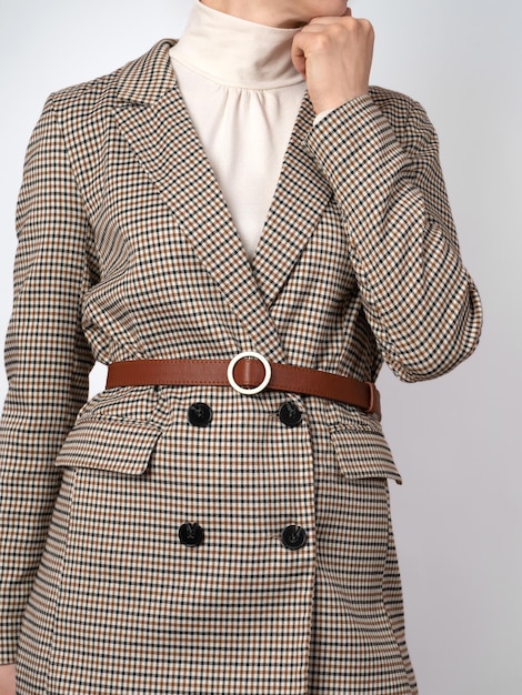 Woman in a plaid blazer and a red leather belt on top Checkered jacket with two rows of buttons Closeup no face