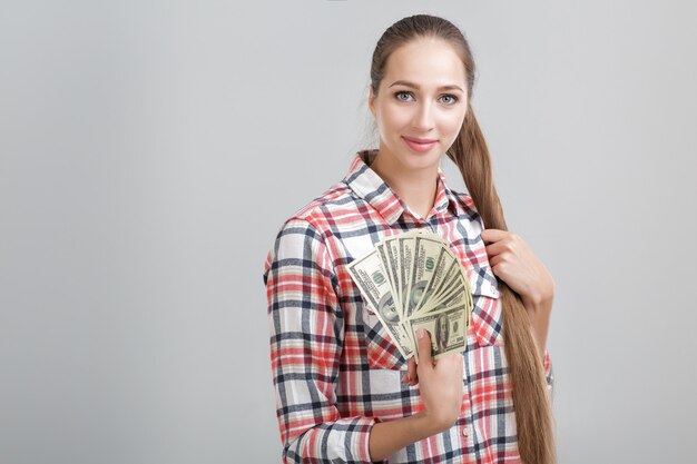 Woman in a plaid shirt holding dollar bills