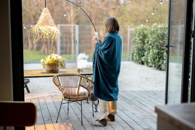 Photo woman in plalid takes photo of flowers at backyard in the evening