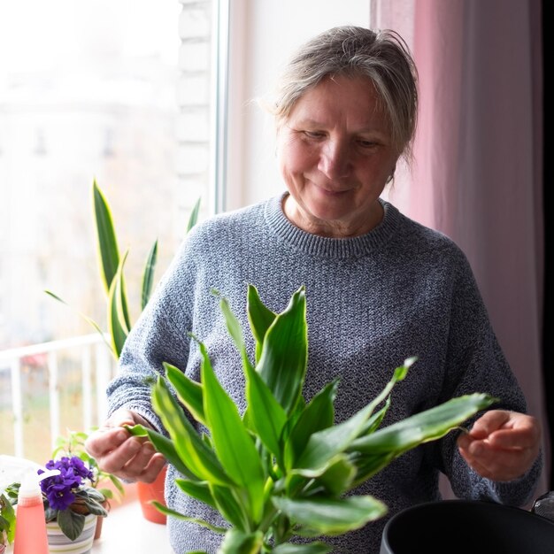 Woman planting a flower and spring cleaning.